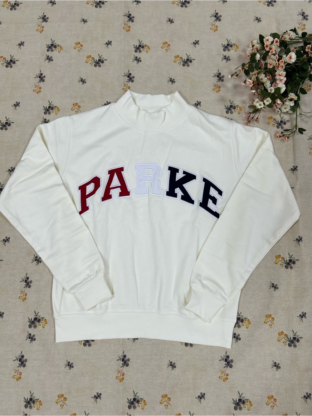 Parker Cream Pullover with Dark Teal Logo Tag